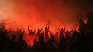 dramatic nighttime photo of warriors silhouetted against fiery red