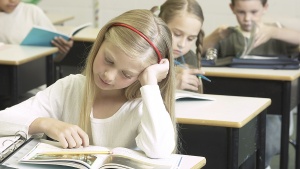 A girl looking at her school book.