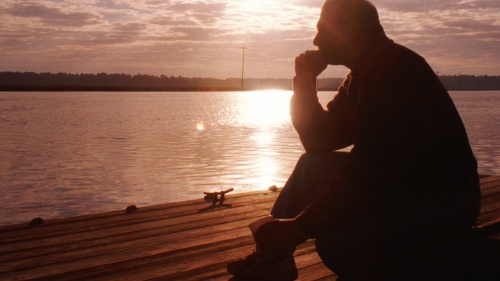 A older man sitting and thinking. 