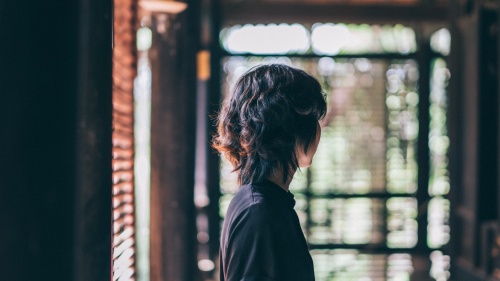 A woman standing alone in a room.