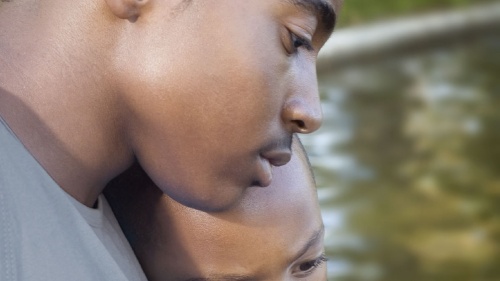 A young man comforting his younger brother.