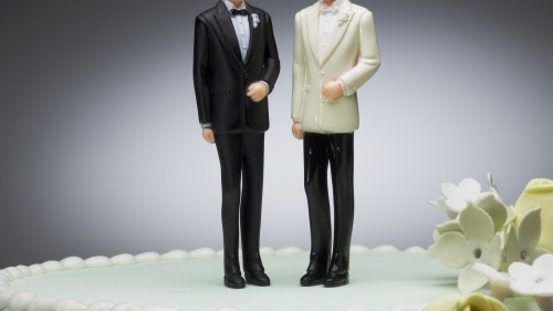 Two men figurines on wedding cake.