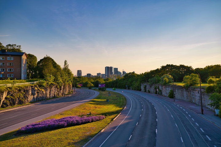 a road running through a village with a cityscape visible on the horizon