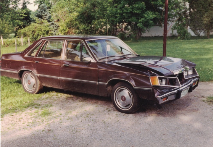 Brown car with dented front hood