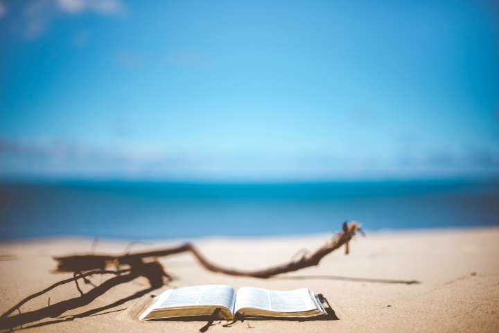 Bible resting on a beach overlooking the sea