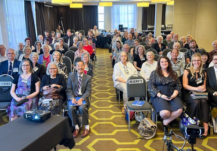 a room full of people seated for a Church service, viewed from the front of the room
