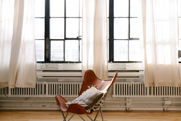 Chair in front of two big windows.