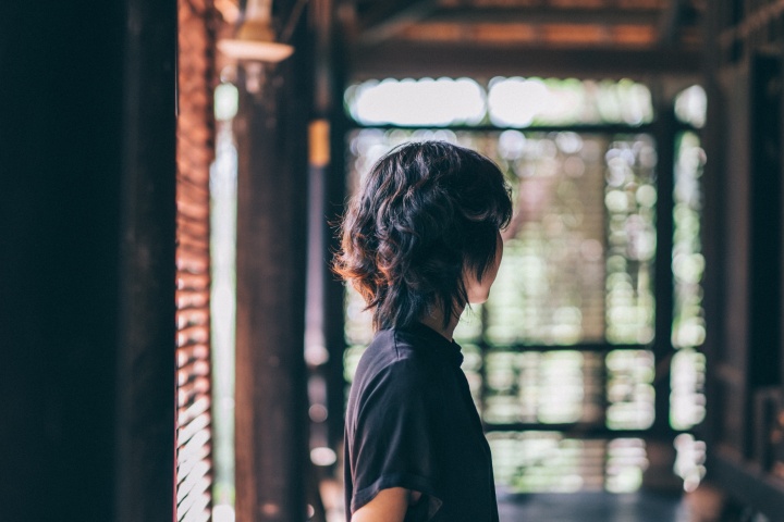 A woman standing alone in a room.