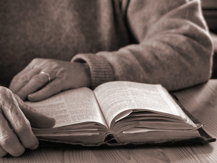 An older person reading a Bible.