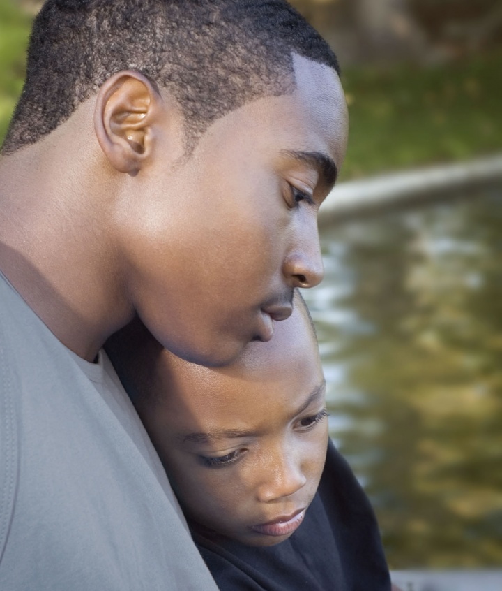 A young man comforting his younger brother.