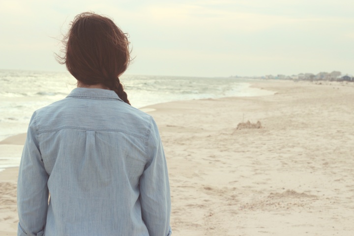 A young woman walking on the beach.