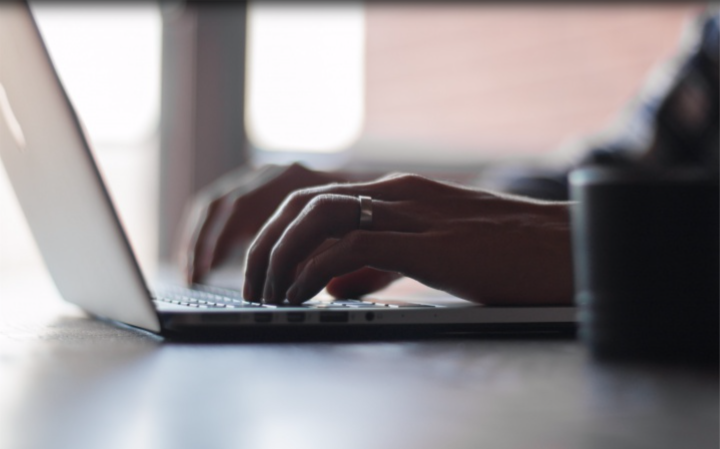 This is a photo of a person typing on a laptop computer.