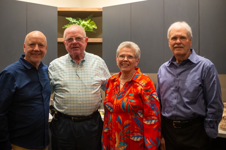 four poeple standing indoors