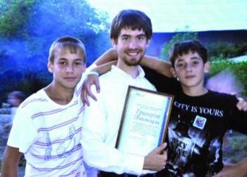 Gregory Zajac with two campers celebrating at the end of a successful camp.