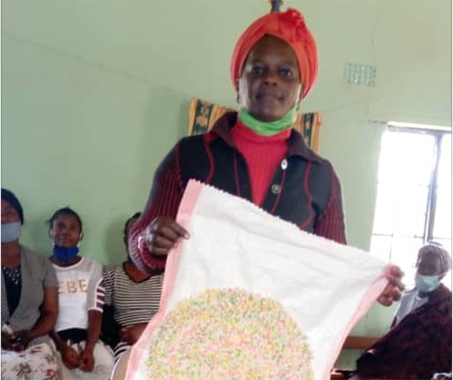 Lucia Mulenga holds up a nearly finished doormat.